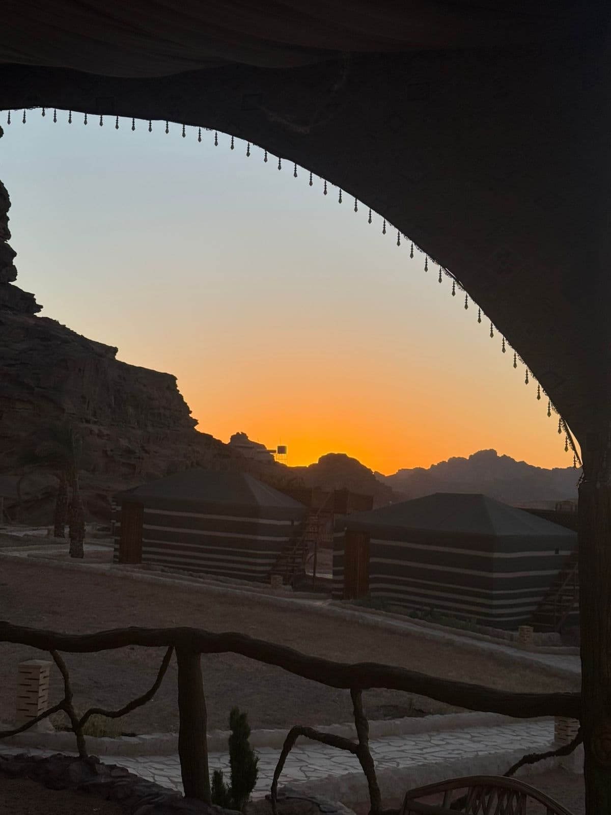 Bedouin tents framed by the camp terrace at sunset