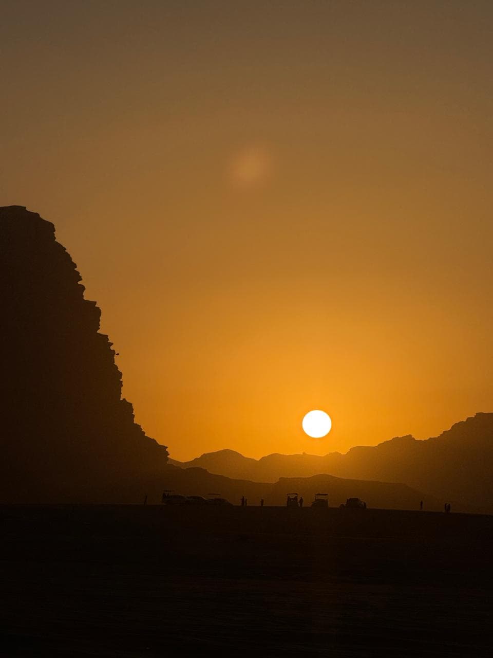 A traveller jumping across the Wadi Rum desert at sunset